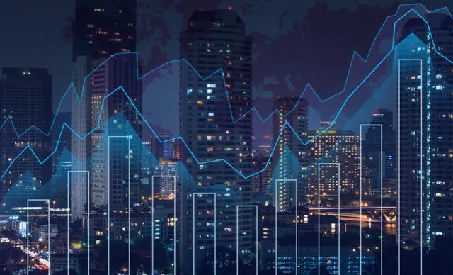 City skyline with financial graph overlays at night.