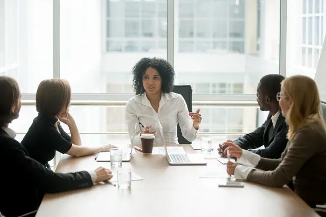 Businesswoman leading a meeting with colleagues in a bright office.
