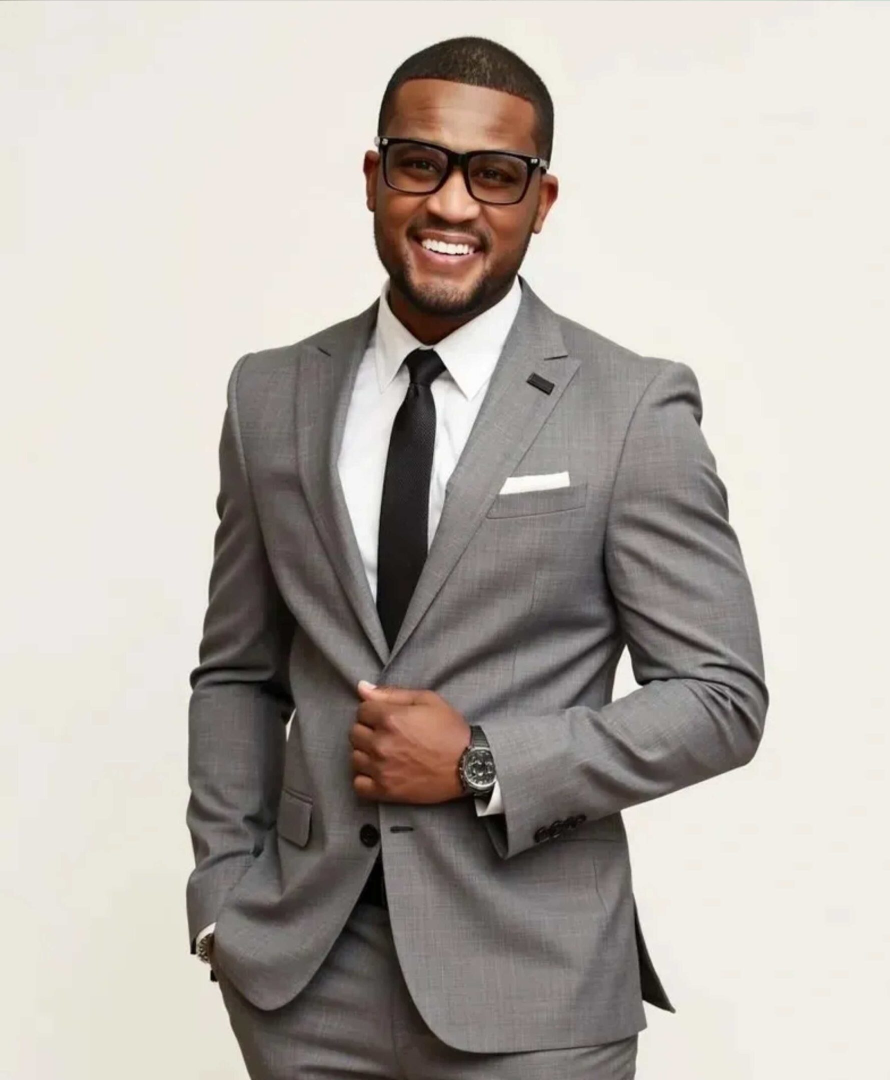 Man in gray suit smiling confidently.
