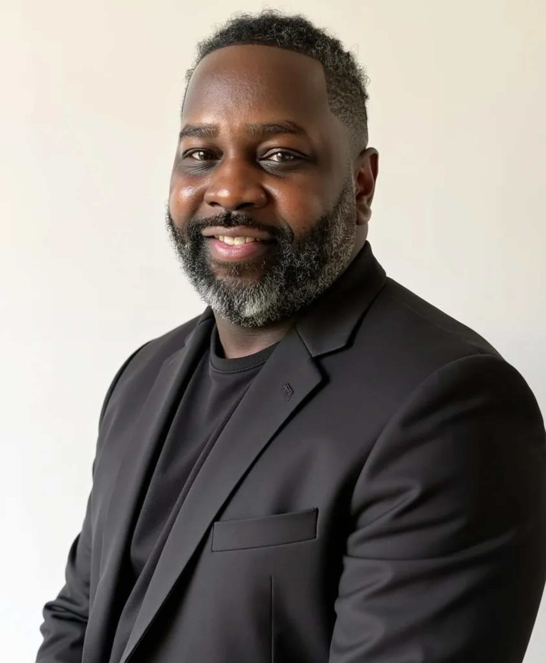Smiling man in a black suit jacket.