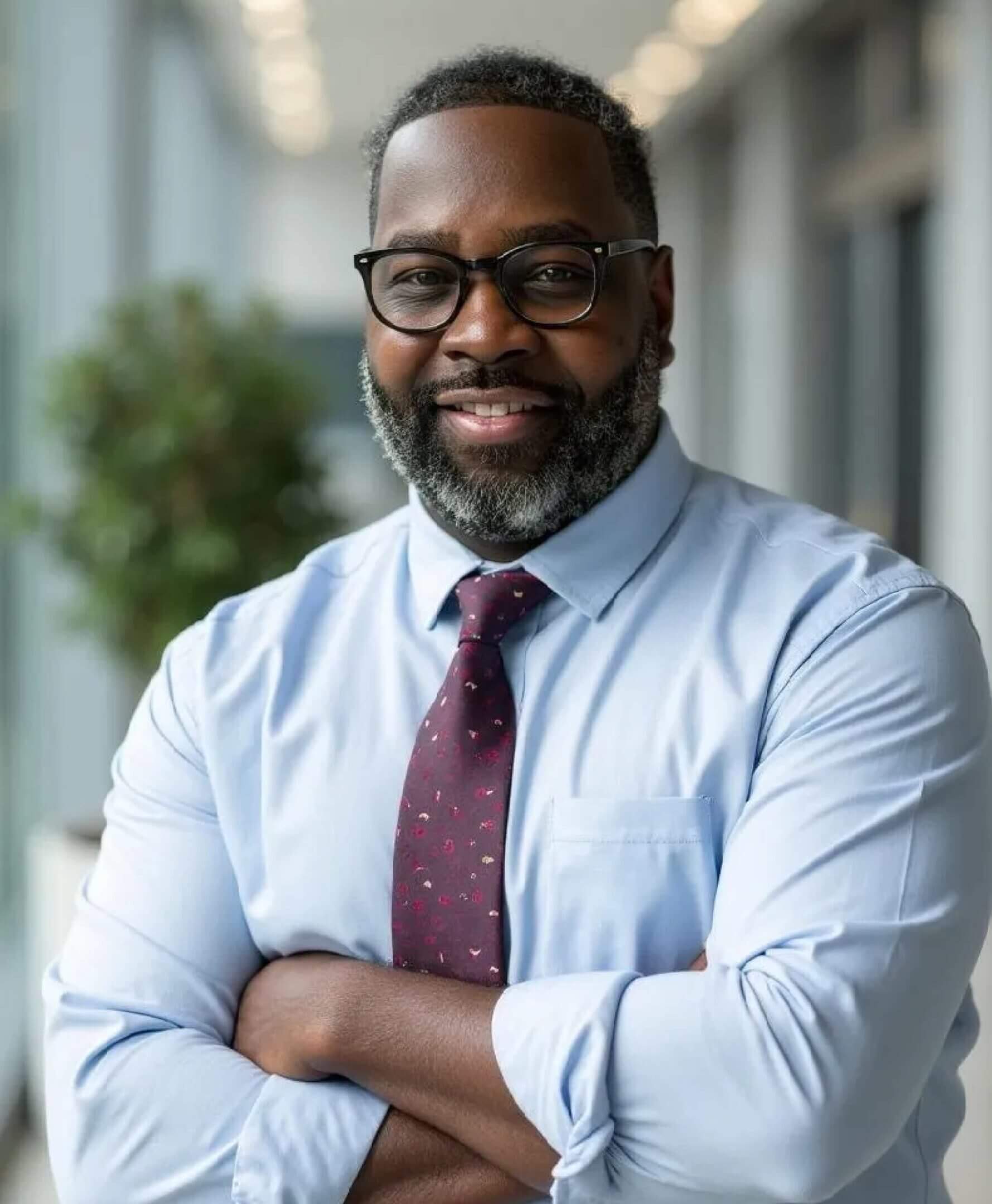 Smiling man in glasses and tie.