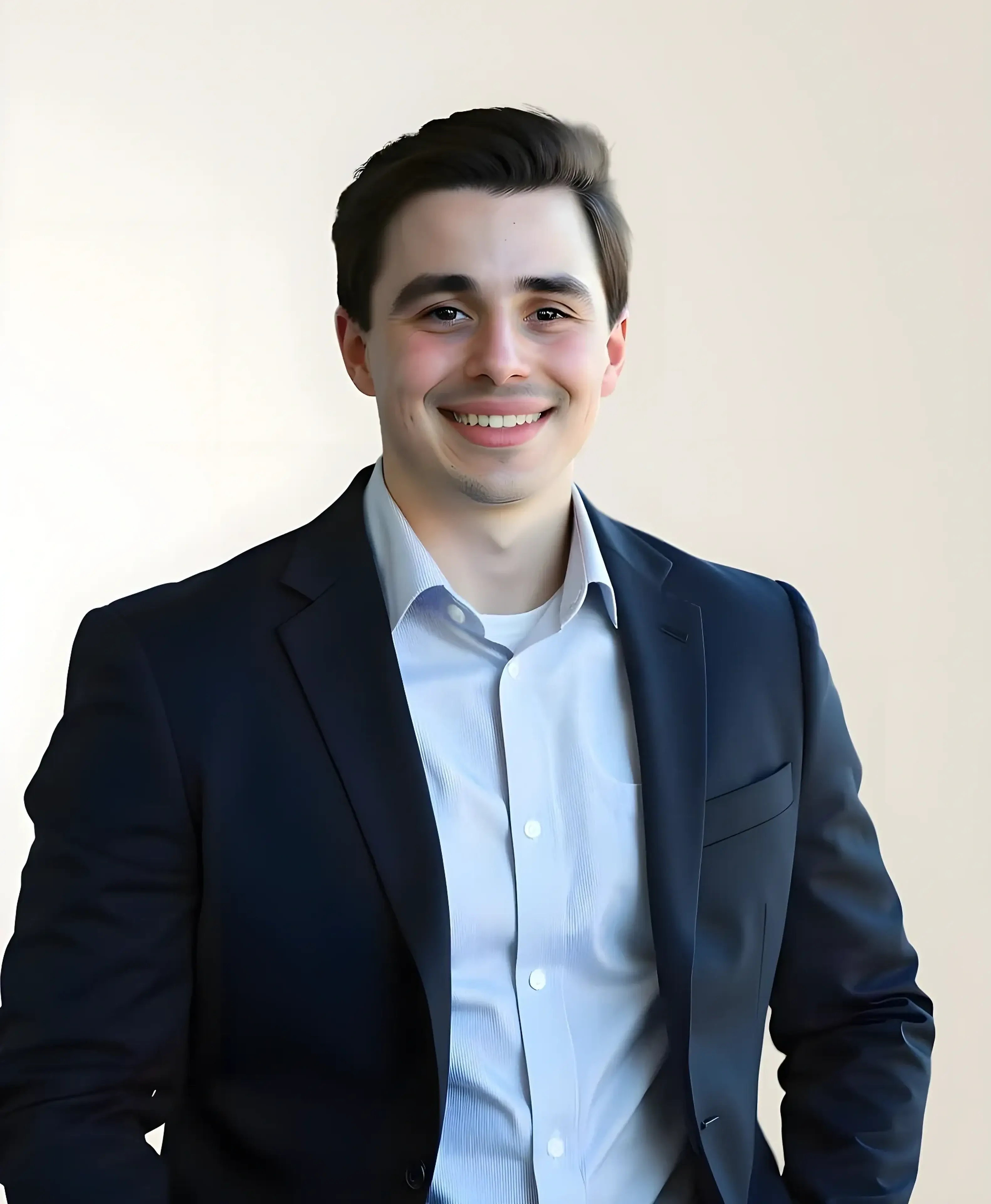 Smiling man in suit with light background.