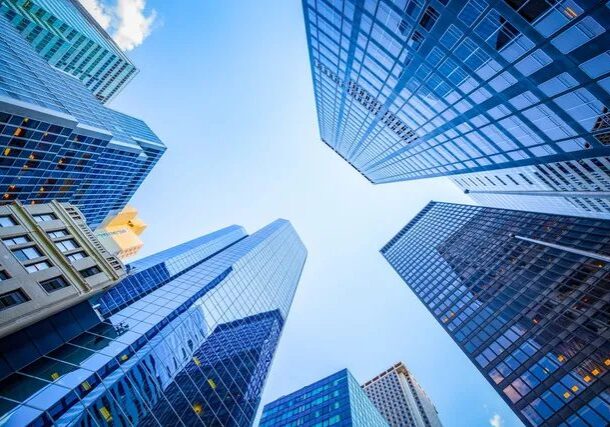 Looking up at towering modern skyscrapers against a clear blue sky.